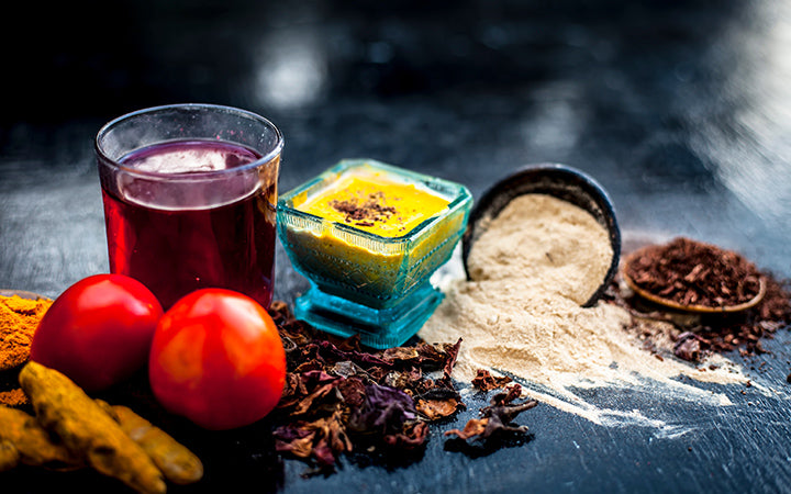 Herbal face pack of tomato and turmeric with sandal wood to make your face glow in glass bowl with raw ingredients.