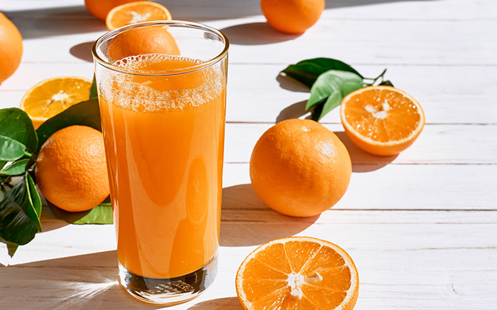 Ripe bio oranges and a glass of fresh squeezed orange juice