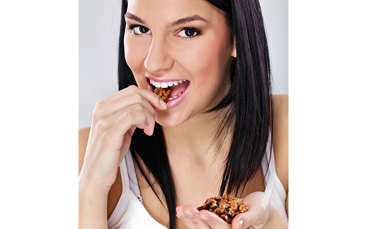 Young woman eating shelled nuts