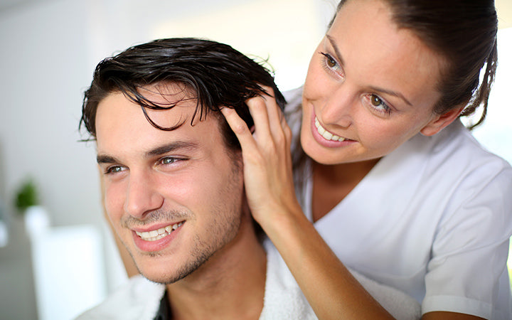 hairdresser doing head massage to customer