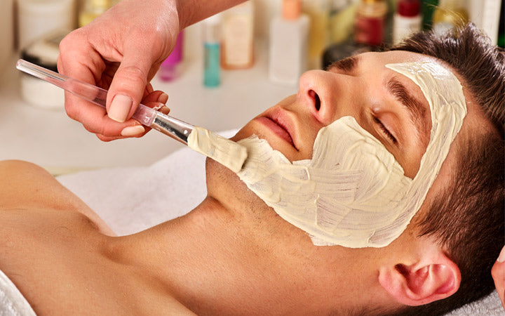 mud facial mask of man in spa salon