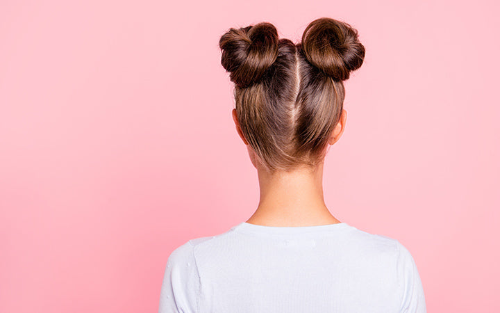 rear back behind view of groomed girl wearing two fashionable buns