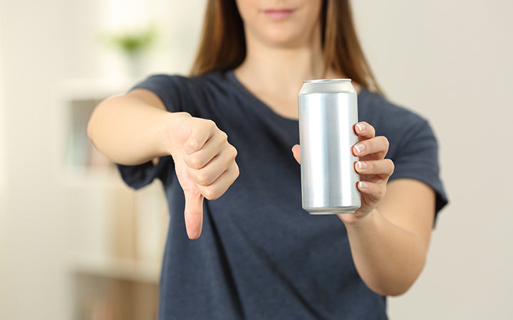  woman hands holding a soda drink can with thumbs down