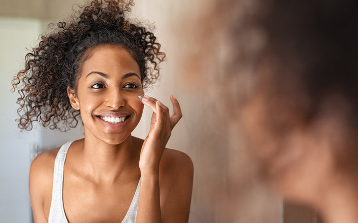 young black woman applying moisturising cream