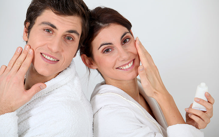 young couple applying moisturizer on their face