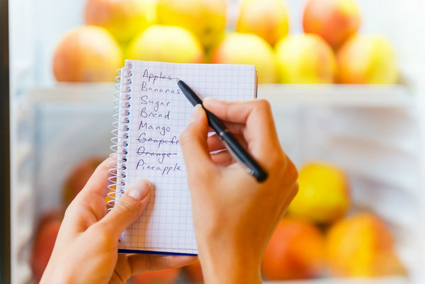 A notebook with a grocery list written in it. 