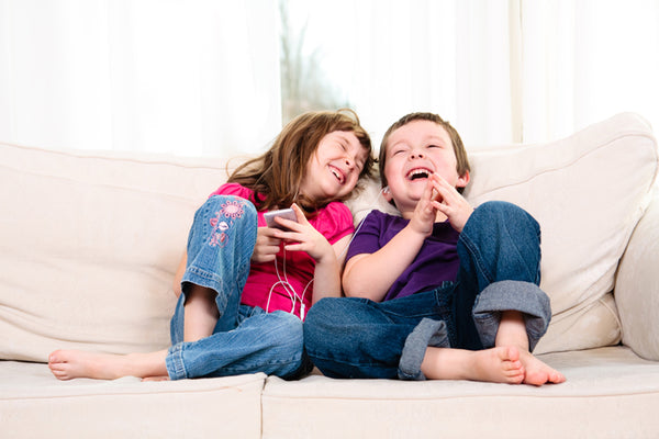 Kids listening music  in a couch 