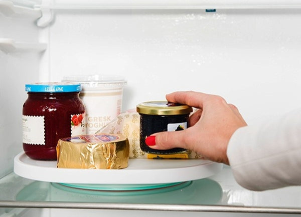 A Lazy Susan being used inside a fridge to provide easy access to condiments