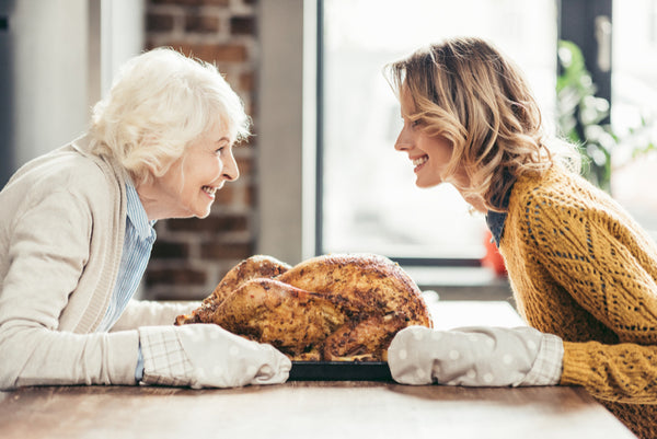 happy senior mother and daughter with delicious turkey on tray