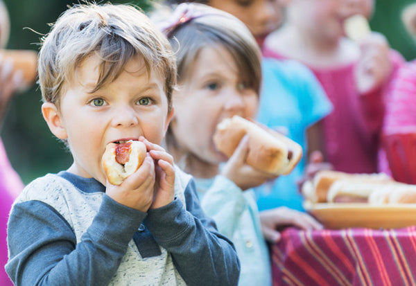 Kids eating hot dogs at a party