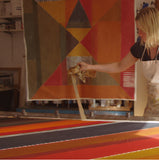 Jane Keith lifting fabric from the table once it has been painted