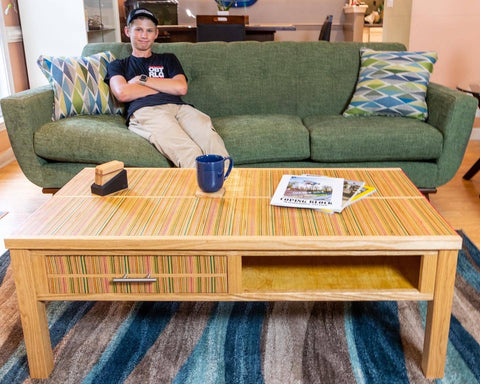 Skateboarder Tyler Dick sitting on a couch with his feet on a custom table.
