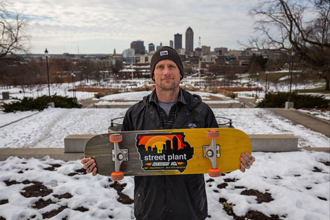 Pro skateboarder Mike Vallely holding up a Des Popsicle skateboard from Street Plant.