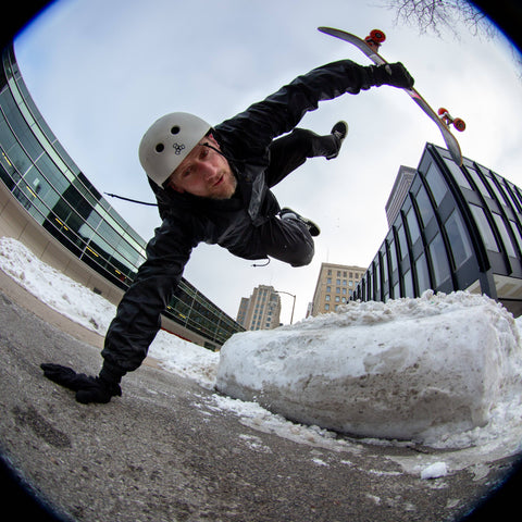 Pro skateboarder Mike Vallely doing a skateboard trick in Des Moines, Iowa with snow on the ground Winter 2021