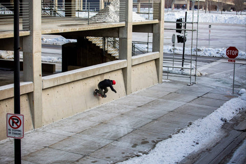 Pro skateboarder Mike Vallely skateboarding on a wall of a parking garage in Winter 2021 in Des Moines Iowa.