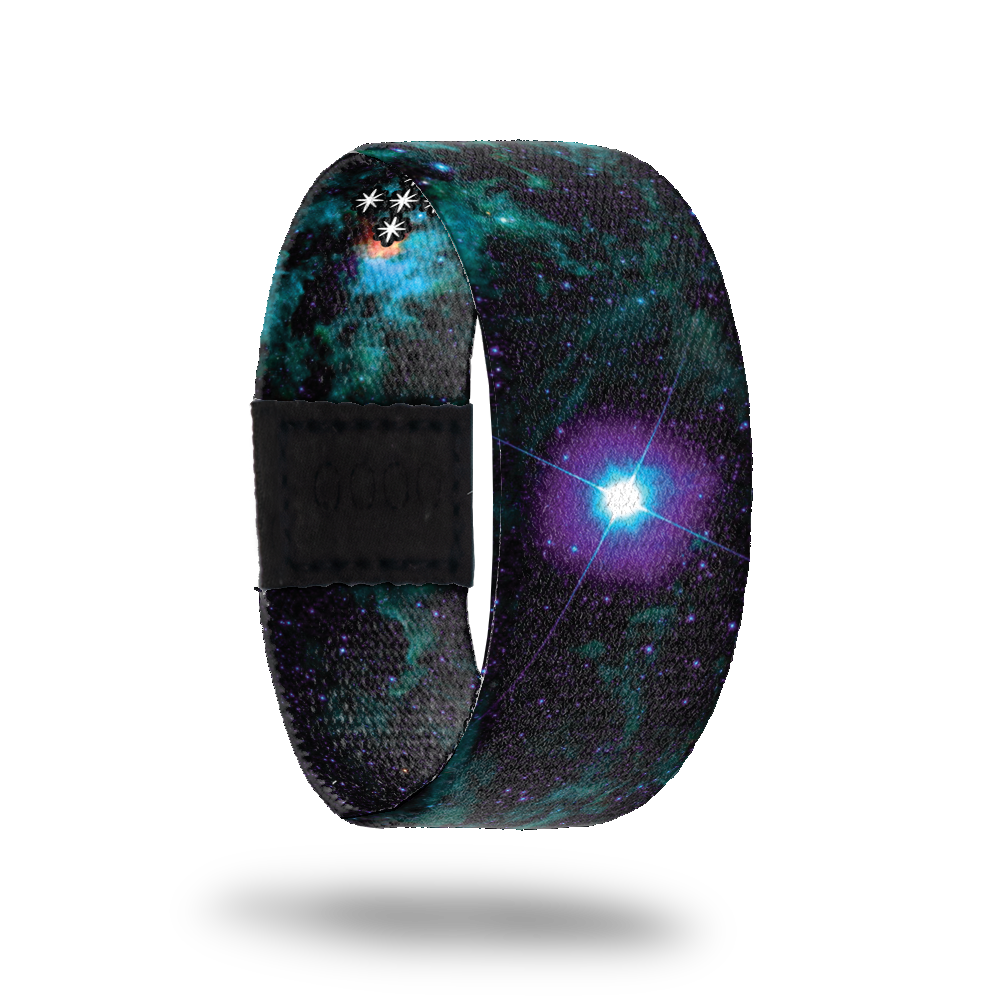 Dark black, green and blue galaxy image. Has one large spot of purple and blue like a bright star. Comes with a matching pin that is iridescent blue and purple. Can only be earned by collecting  100 white tickets.