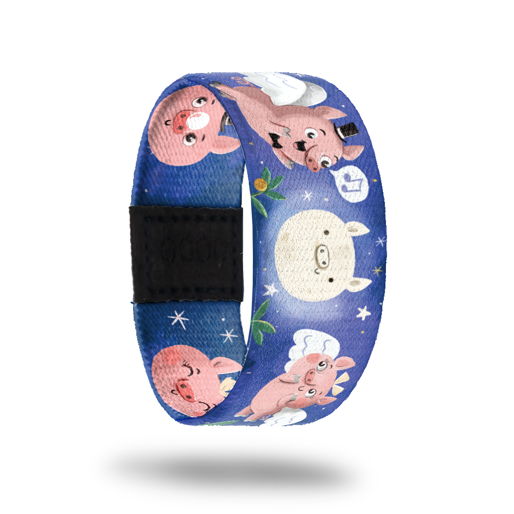 Blue strap with pigs flying with wings in the moonlight and singing. Inside is the same and says Anything Can Happen. Comes with matching lapel pin and collector's box. 