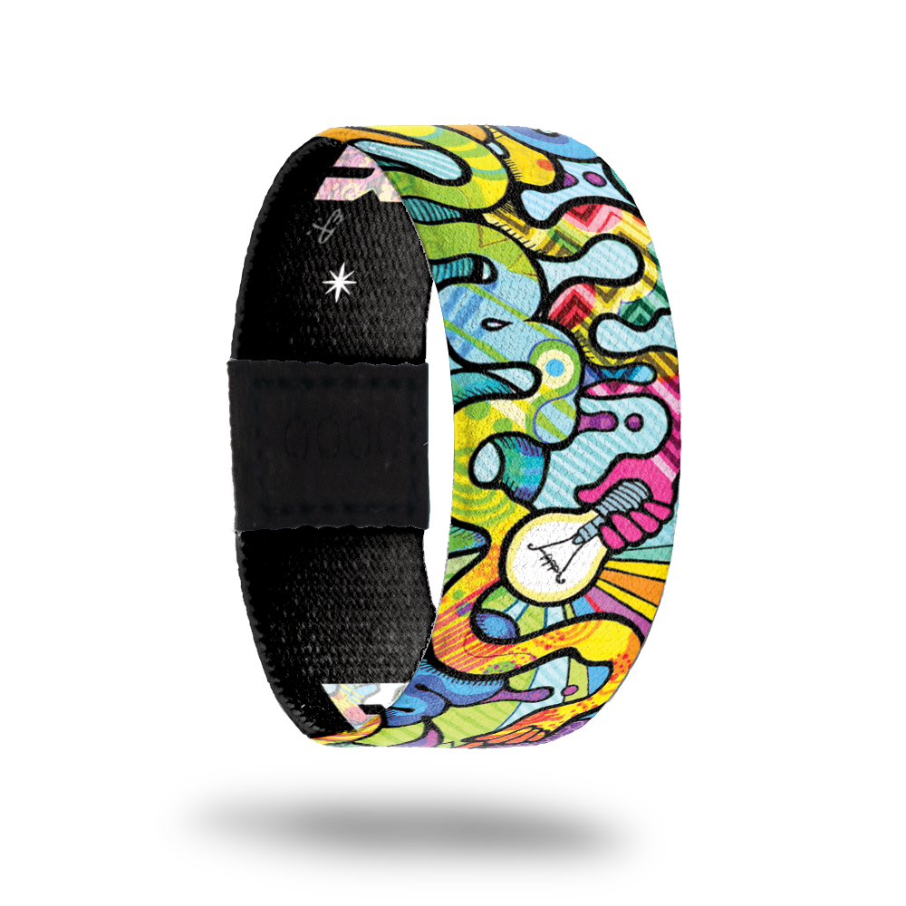 Brightly colored "brain" design with abstract designs inside. Hand holding a lightbulb in the center. Inside is solid black and reads Brainpower in multicolored lettering. 