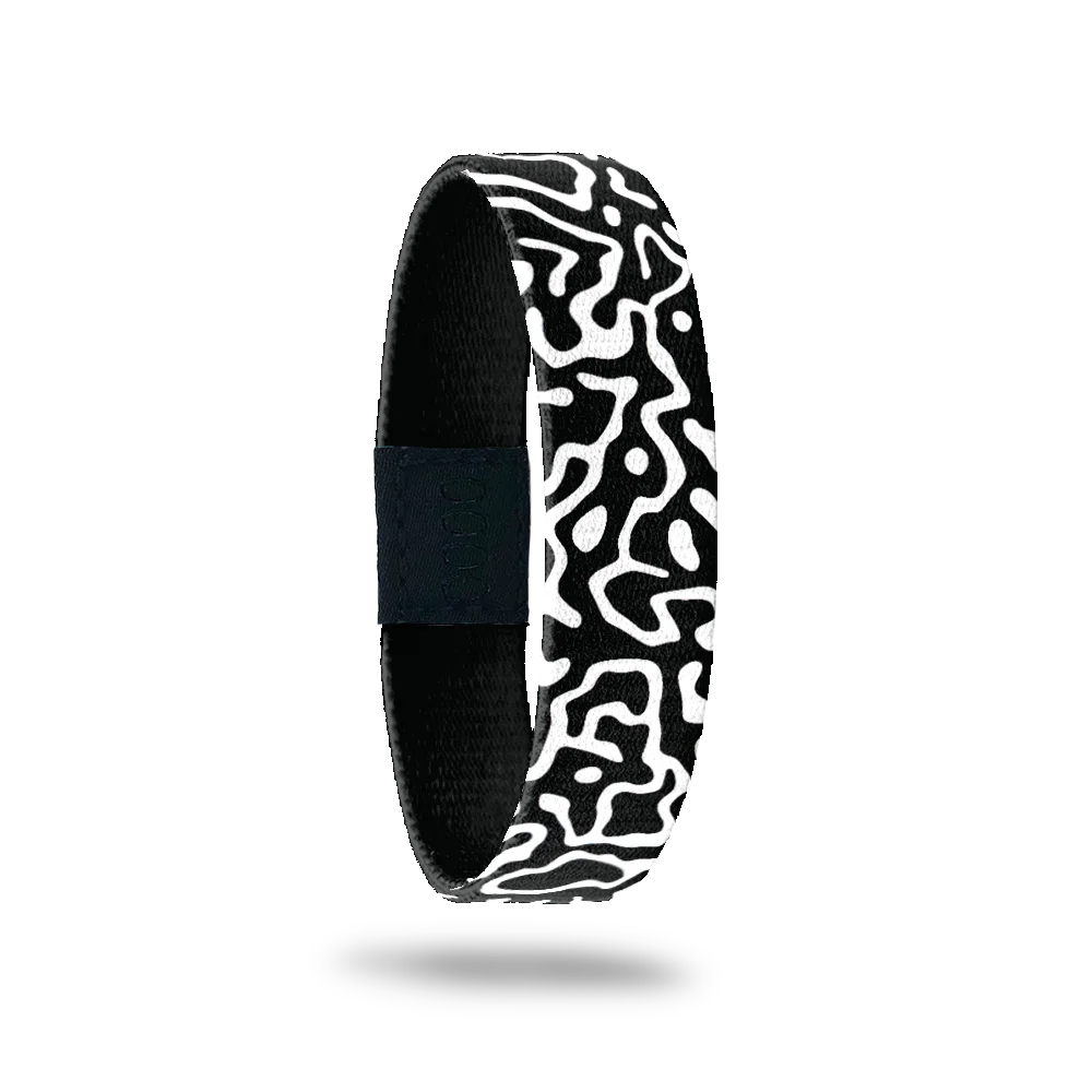 This is a reversible wristband. One one side is a black base with white swirls all over. The inside is the same design and reads Brave Enough To Be Yourself.. It is a single.