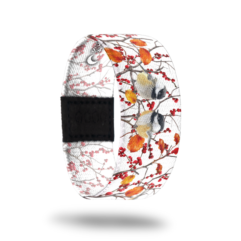 This is a reward and not a purchasble item. It is a reversible strap for the Birds and Blossoms mini collection. The strap is white and has trees with various birds nesting and red berries all over. It comes with a matching lapel pin and the inside reads Choose Serenity. 