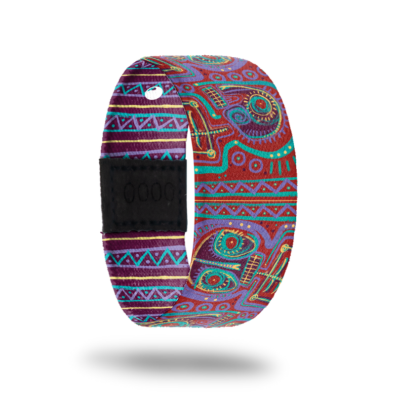 ZOX strap with an abstract design of purple, red, teal and gold. Comes with a matching lapel pin and reads Defy The Odds on the inside. All items come in a matching collector's box. 