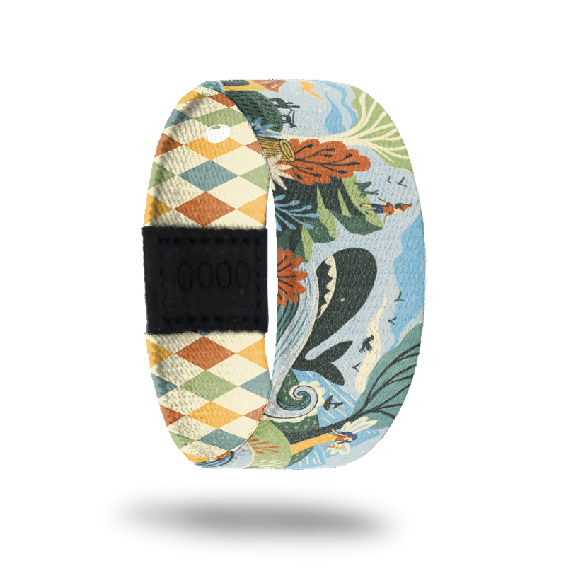 ZOX strap with cartoon design of little boy watching a whale in the ocean on the side of a mountain. Colors are muted orange, beige, blue and green. Comes with a matching pin and collector's box. 
