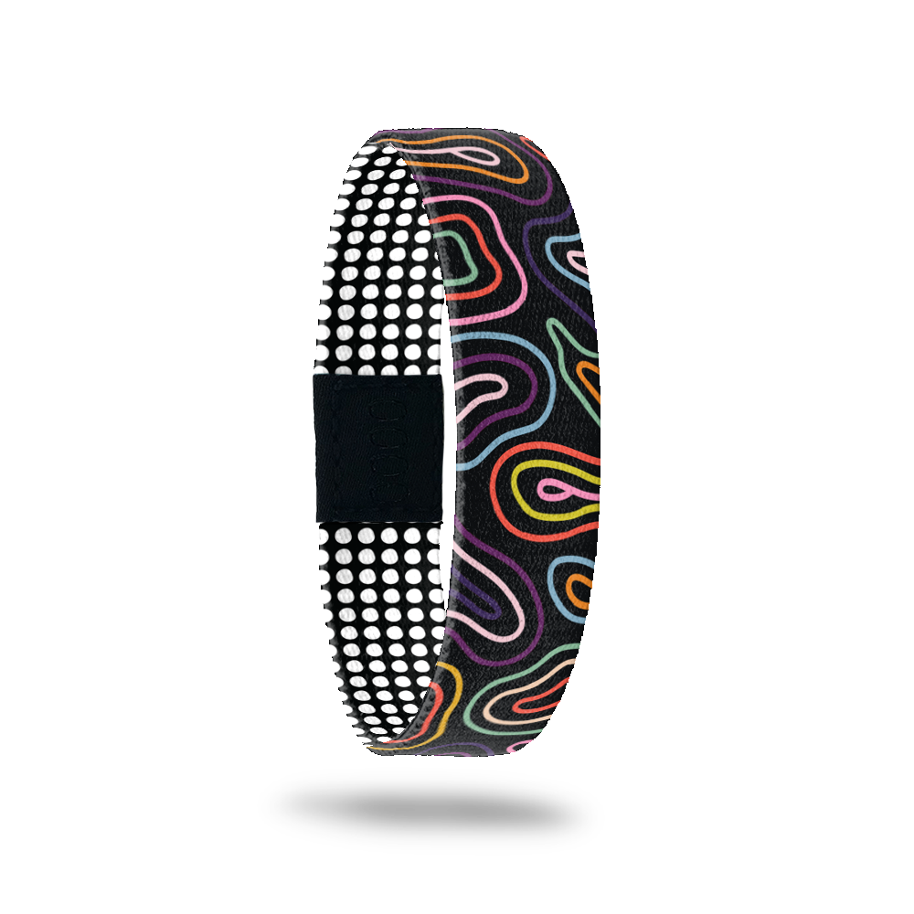 ZOX single with black base and multicolored swirls on the outside. Inside is a black base with white symetrical dots and reads Expect the Unexpected. 