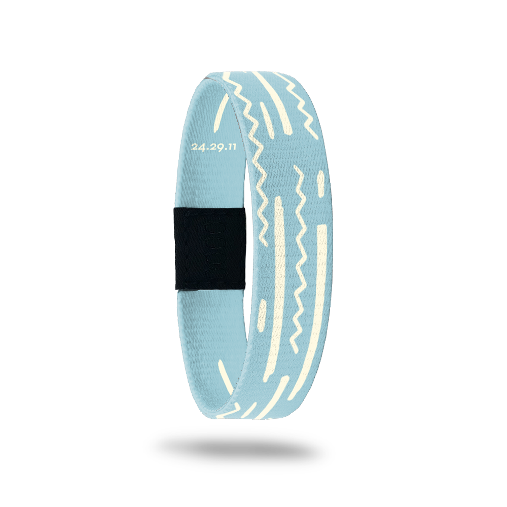 Wristband wih pale blue base and off-white squiggles and lines along the band. Inside reads God's Plan and has Bible verse 24.29.11.
