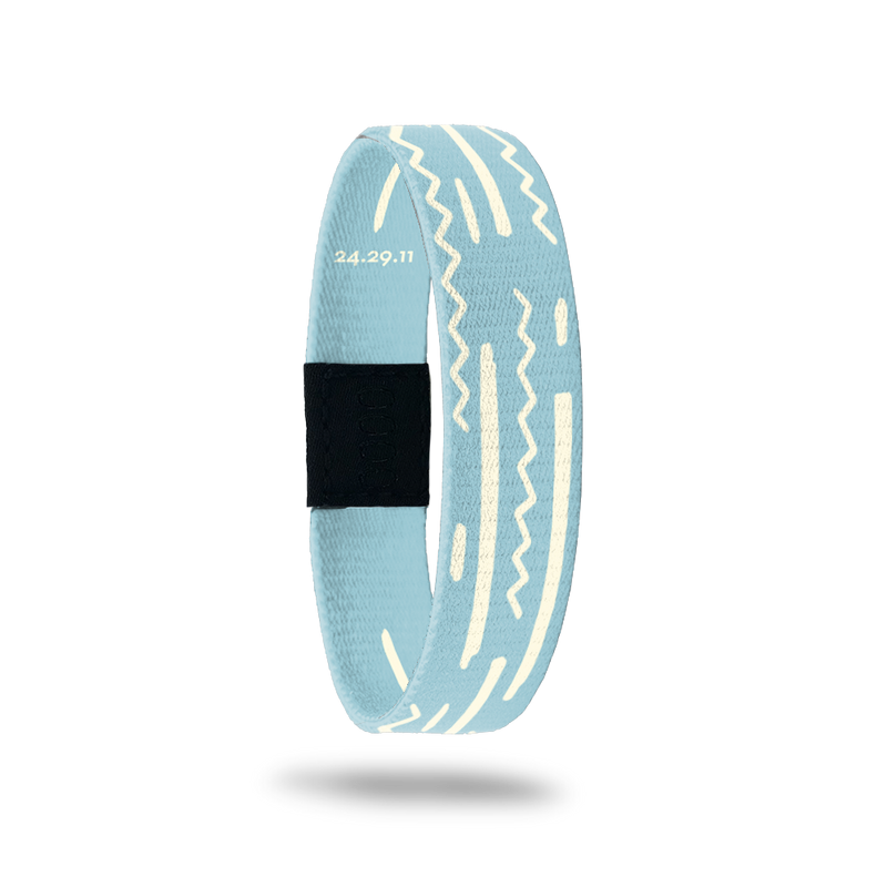 Wristband wih pale blue base and off-white squiggles and lines along the band. Inside reads God's Plan and has Bible verse 24.29.11.