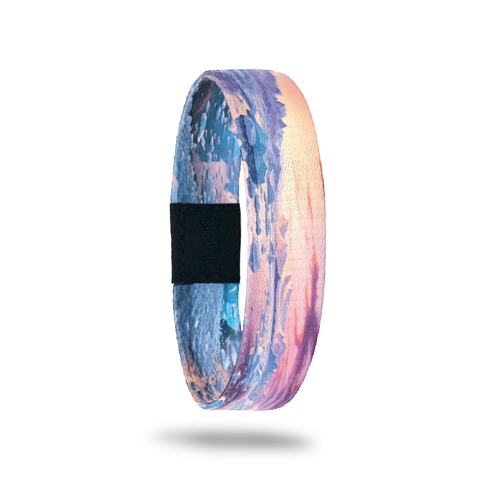Wristband single with a sunset view of icebergs and the shoreline with blue, pink, orange and yellow. The inside is the same and reads Ice Age.
