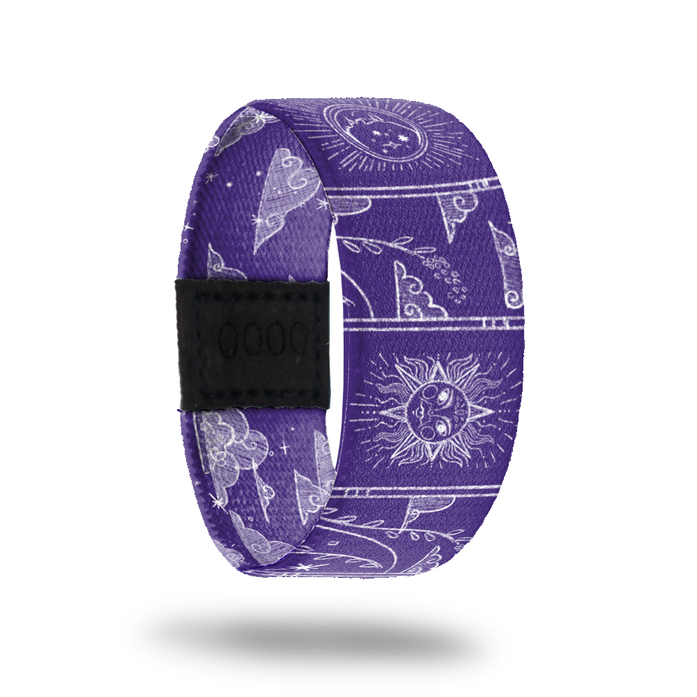Wristband strap that is purple all over and has white outlines of moons, sodiac images, clouds, vines and suns. The inside is the same and says Make It Count.