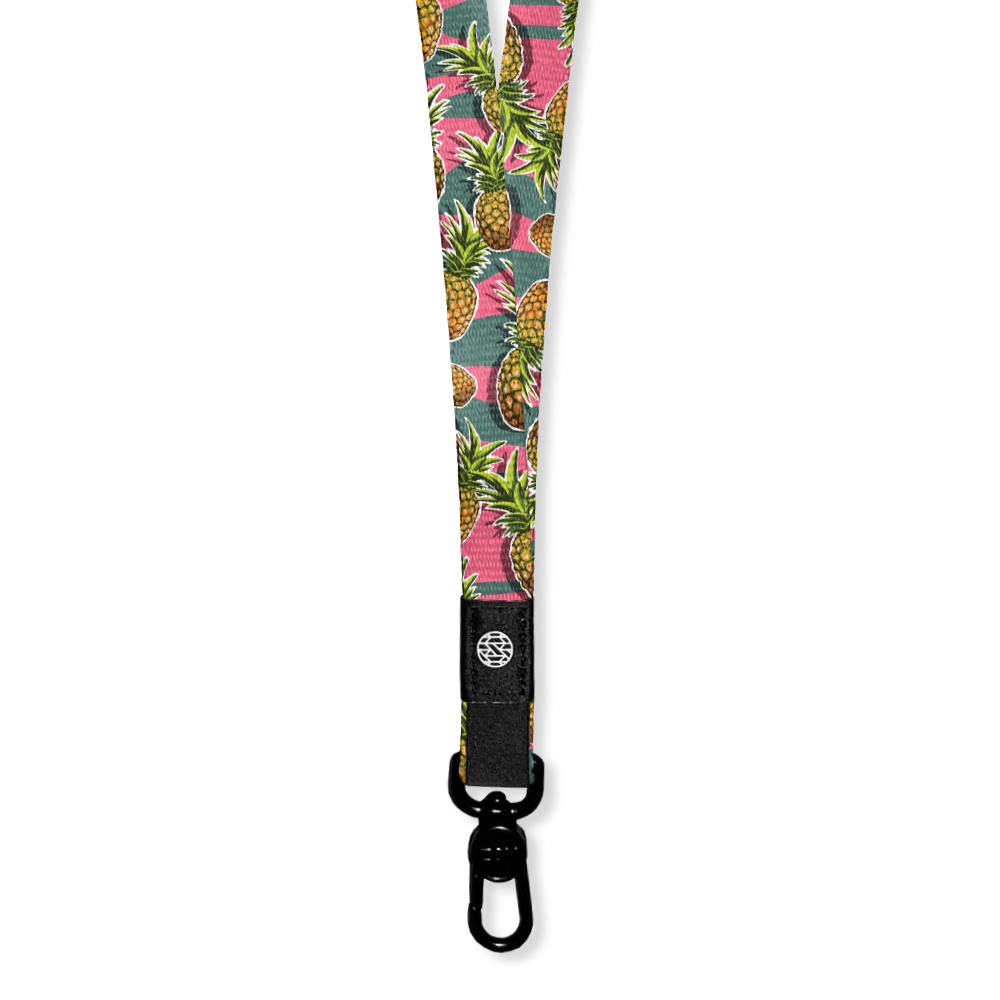 A lanyard with a green and pink horitzontal straip design. On top of the lines are pineapples all over and the inside reads Ohana. The lanyard has a metal pull-down clip but comes with two extra attachments to create a breakaway version too.