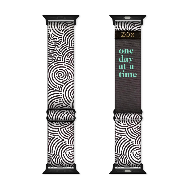 Watchband with a black and white circular maze design all over. The inside is the same and in teal reads One Day At A Time. Check the size guide for compatible watches. 