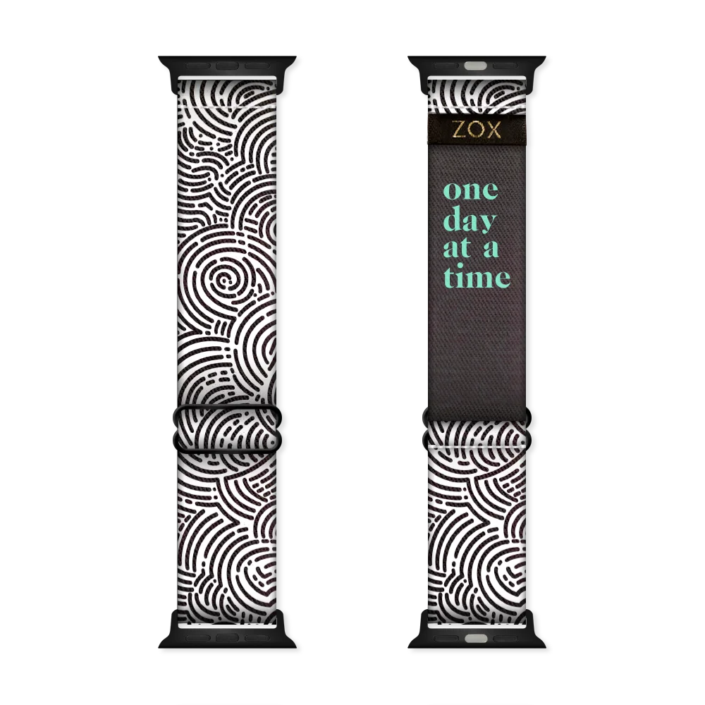 Watchband with a black and white circular maze design all over. The inside is the same and in teal reads One Day At A Time. Check the size guide for compatible watches. 