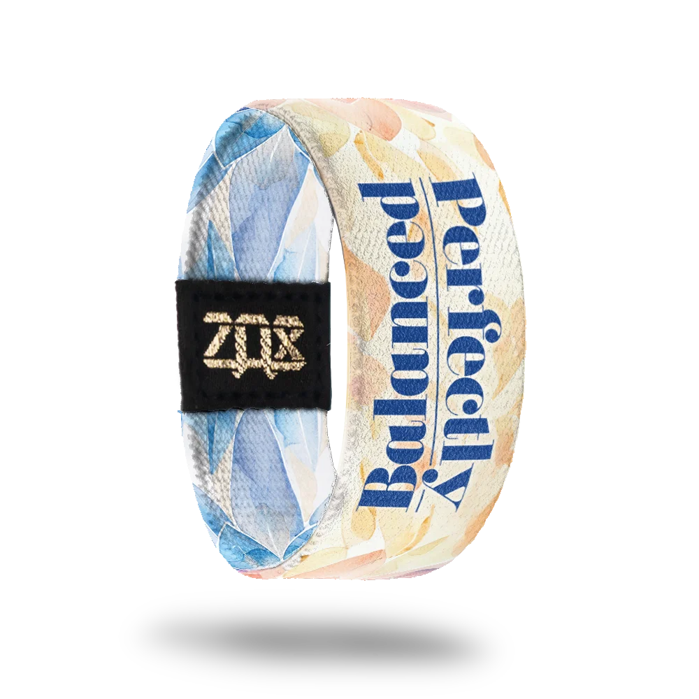 Product photo of the inside of the Perfectly Balanced which continues the watercolor design with pastel shades of blue, pink, and beige. Bold blue text reads "Perfectly Balanced" vertically along the strap. A black patch with a gold "ZOX" logo is also visible.