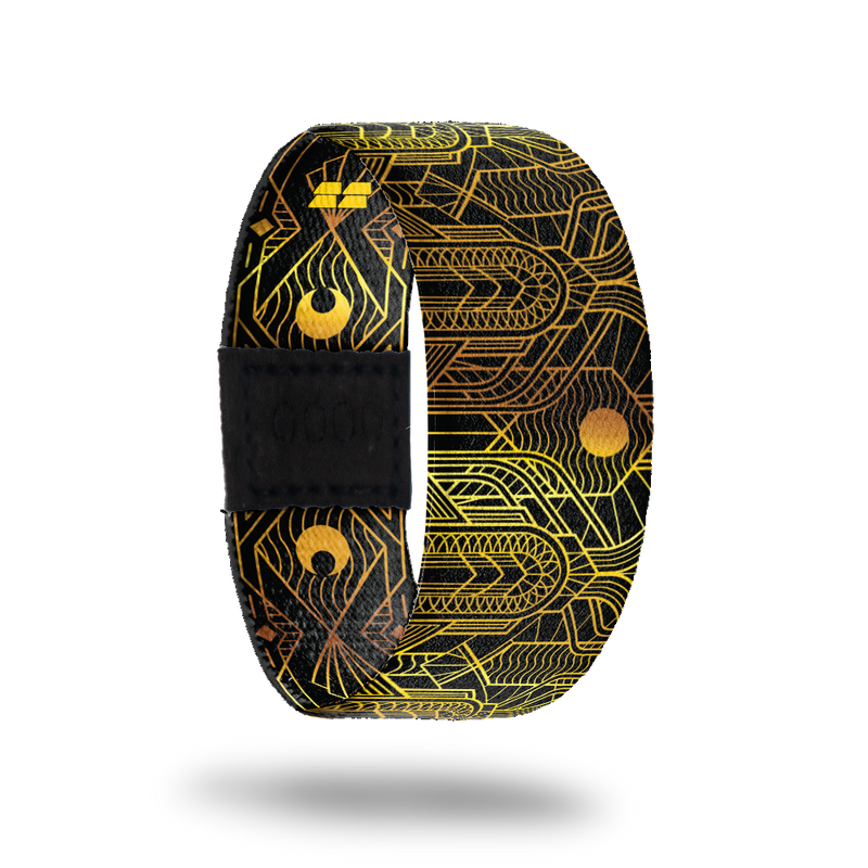 This is a reward, do not purchase. Black strap with gold lines all over in an abstract pattern. The inside is the same and reads Speak Easy. Comes with a matching lapel pin.  