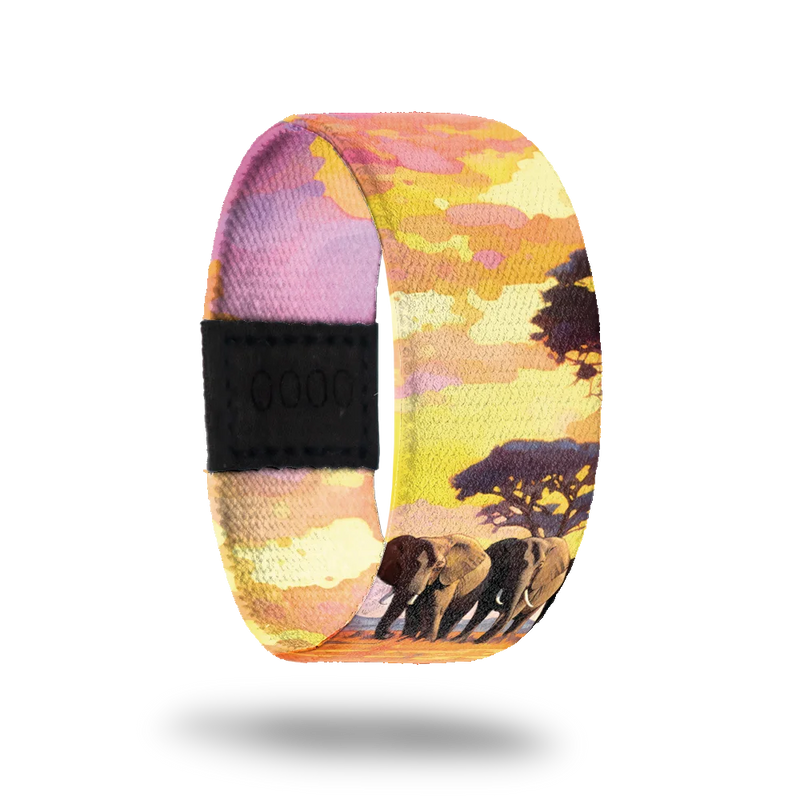 Outside is a pink, yellow and orange African sunset with elephants. Inside is the same sunset with "Strength in Unity" written. 