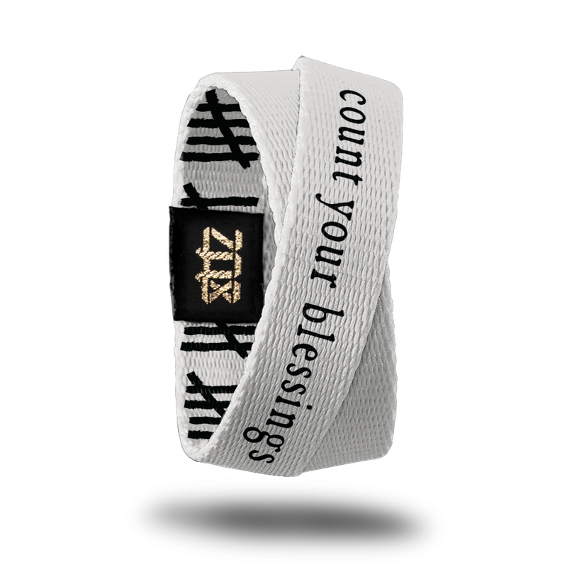 Inside design of Count Your Blessings is a white-grey background with Count Your Blessings in black text centered on the design. This product, called a double, is thinner and wraps around your wrist twice with the material crossing at one point.