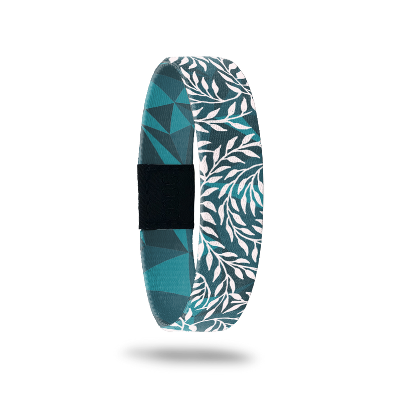 Wristband single that is teal and turquoise geometric design. It has all white vines on top that wrap around the band. The inside is the same design without the vines and says Hope Over Fear. 
