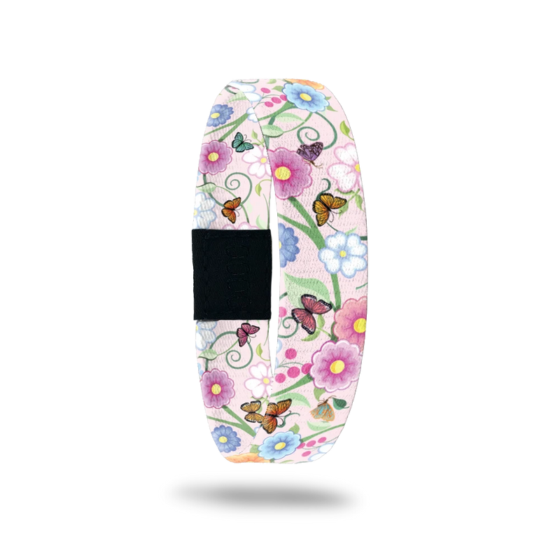 Wristband single with a very light pink base. The design is mulitcolored and has glowers and butterflies all over. The inside is the same and says I Love You Mom. 
