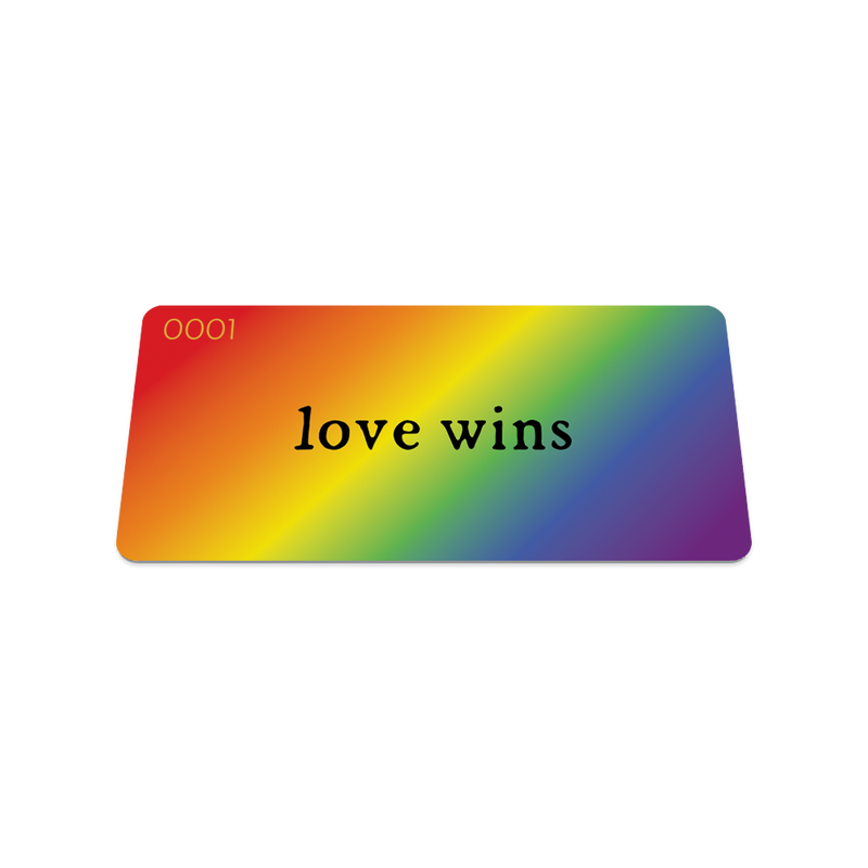 Front collector's card image of Love Wins: rainbow gradient with black text ‘Love Wins’ on strap