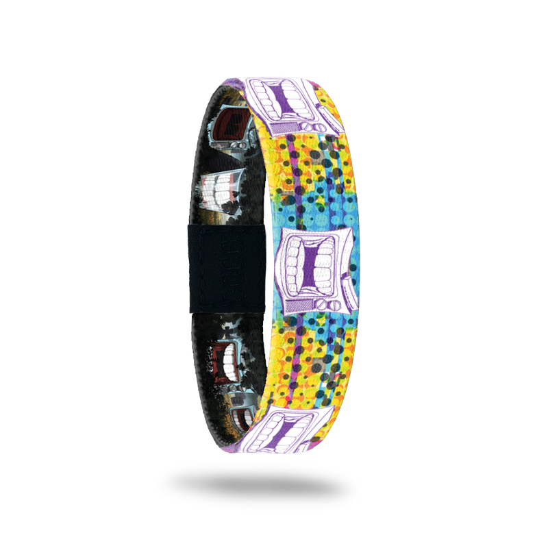 Bracelet is multicolored with yellow, teal and range dots/design. Has an old-school TV with chatter teeth on the design. Comes with a pin of a chatter teeth set. 
