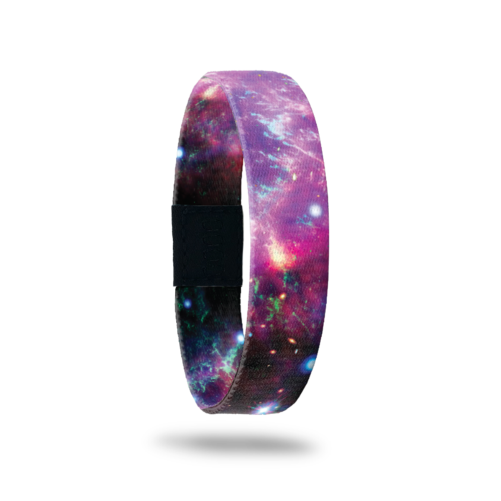 Wristband single with a purple and black Nebula design with hints of blue and pink. Inside is the same and says One Step At A Time. 