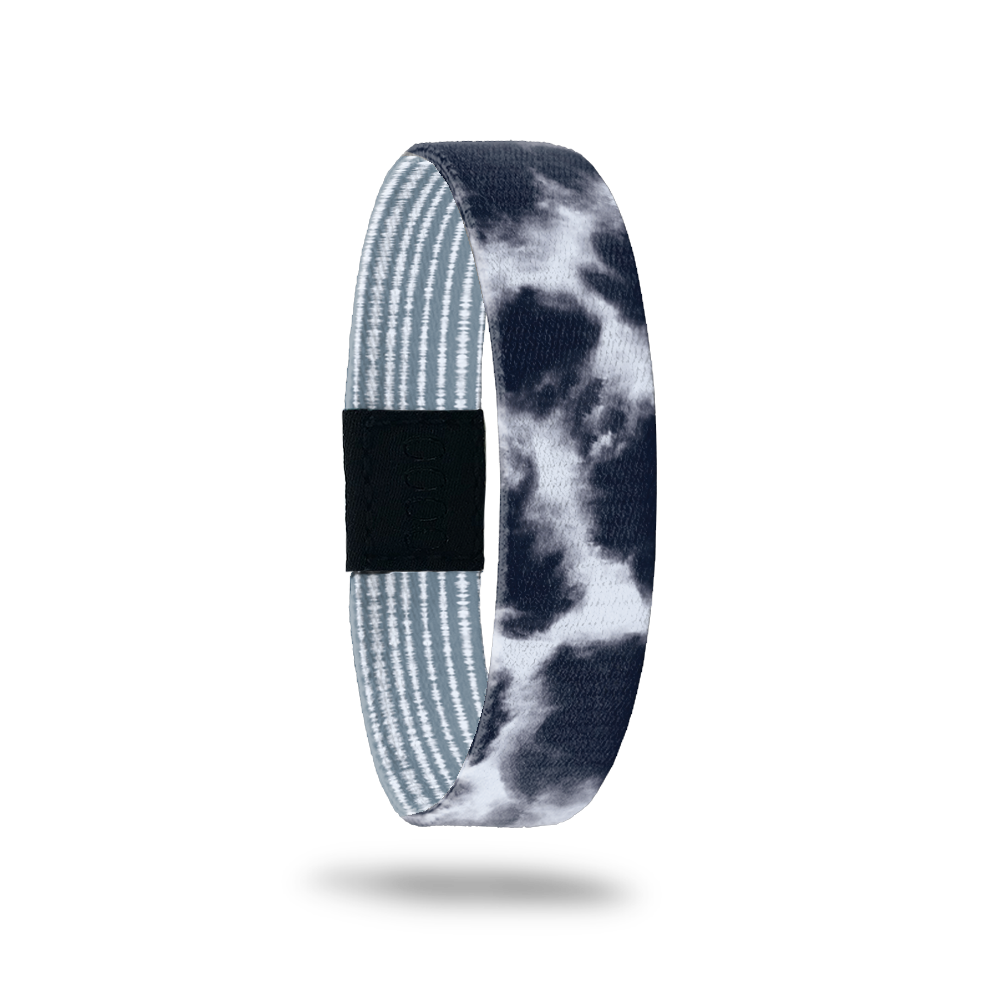 Wristband single with a greyish blue and white cloud design. The inside is pale blue and white stripes and reads Quiet Your Mind. 