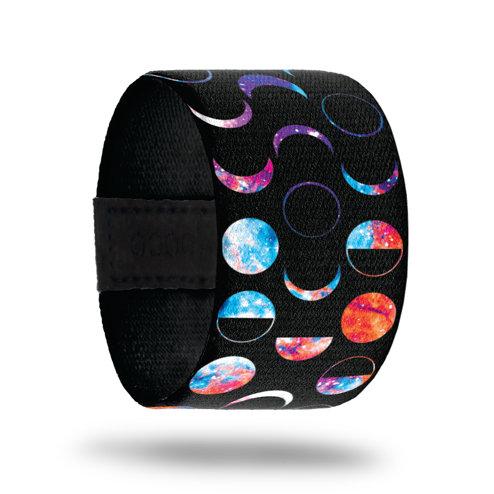 This is a reward item only, do not purchase. The strap is much wider than normal and has a black base. It has the phases of the moon in multicolors. The inside is plain black and reads Unphased. 