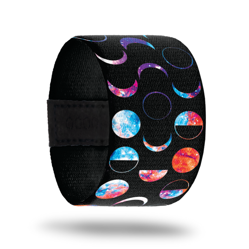 This is a reward item only, do not purchase. The strap is much wider than normal and has a black base. It has the phases of the moon in multicolors. The inside is plain black and reads Unphased. 