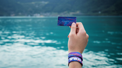 WWJD Wristband at a lake in Switzerland with a card saying "What Would Jesus Do?"