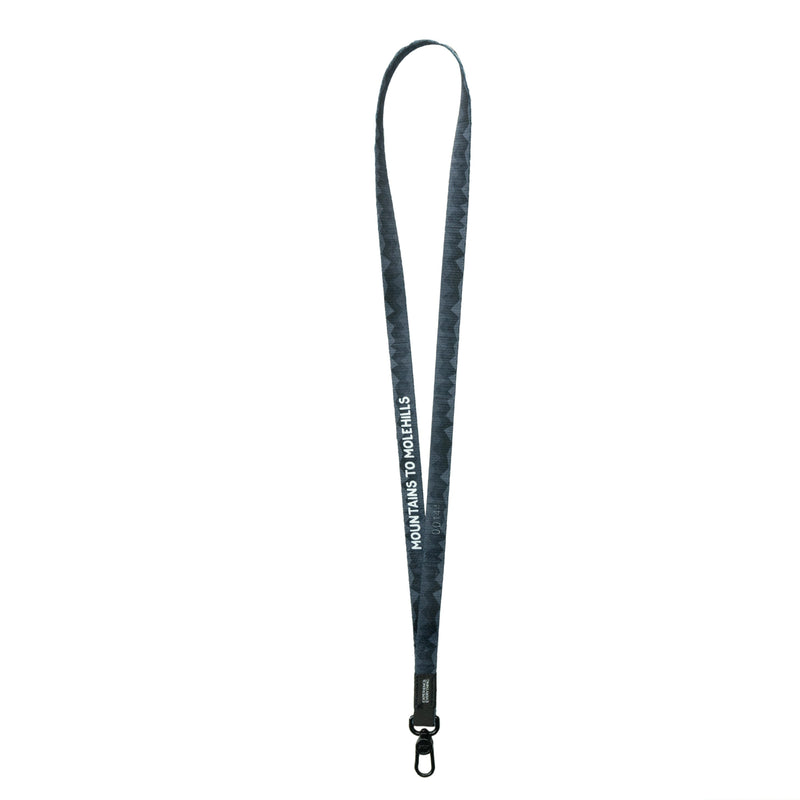 A product image of a ZOX lanyard showing the back of the design with a black colored metal clip. The lanyard is called and says Mountains To Molehills and the design is a grayscale version of the front design which is a geometric version of a mountain range