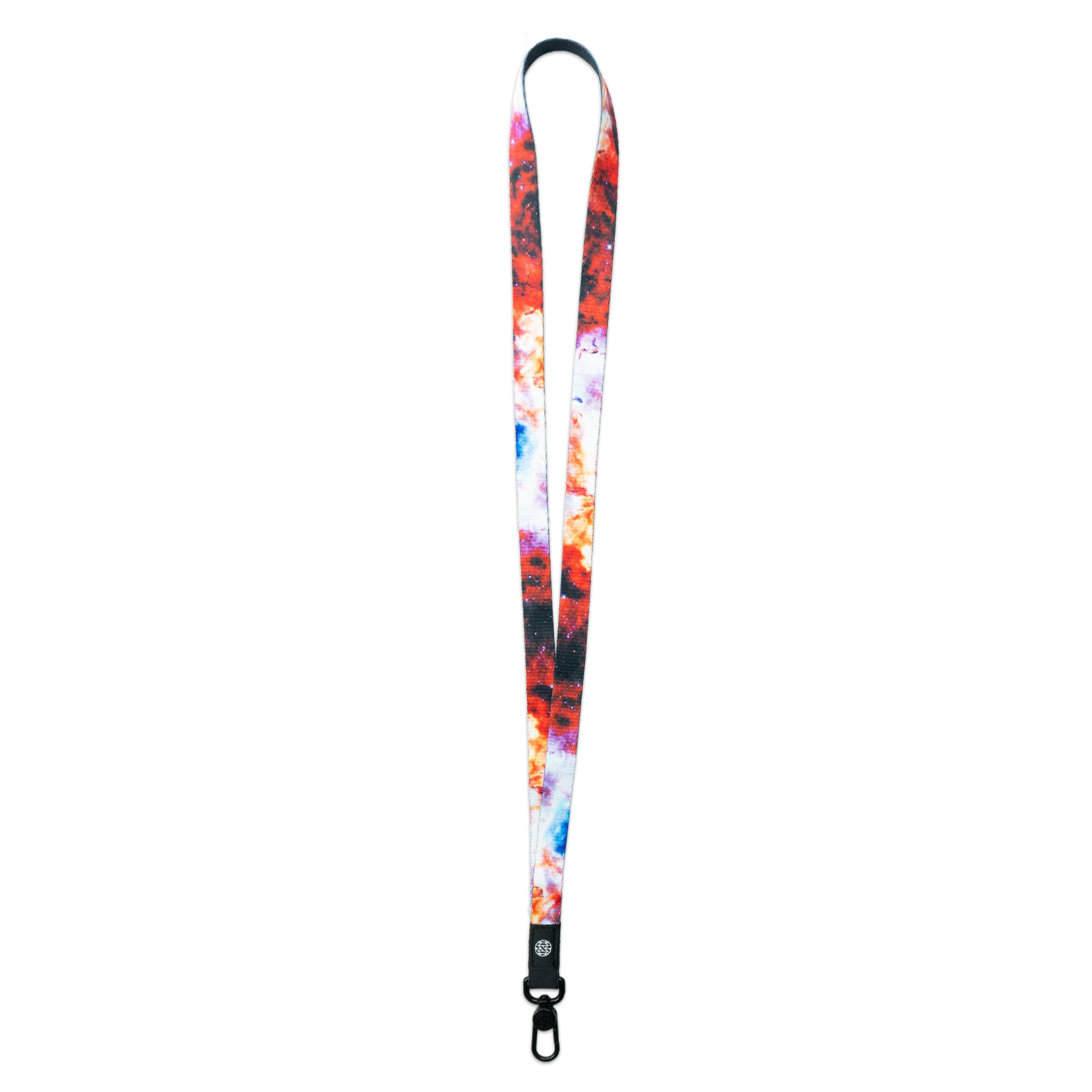 A product image of a ZOX lanyard showing the front of the design with a black colored metal clip. The lanyard is called Let There Be Light and the design is a photo of a space nebula that is red, brown, pink, and blue 