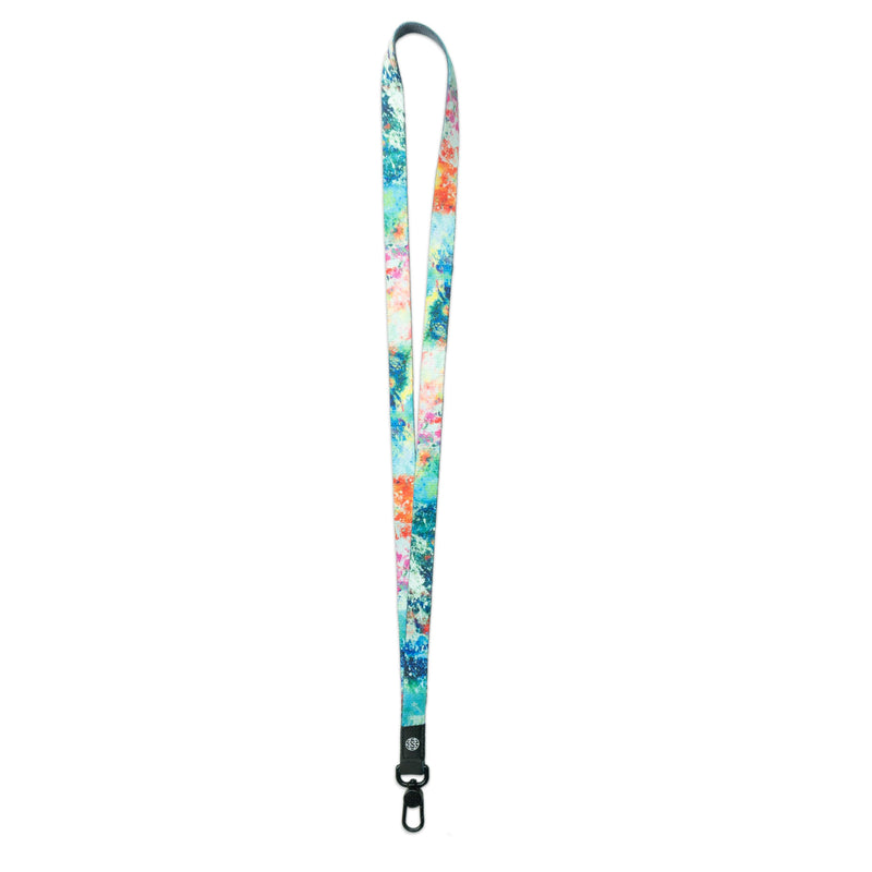 A product image of a ZOX lanyard showing the front of the design with a black colored metal clip. The lanyard is called I Got This and the design is a multi colored paint splatter that is a mix of blues, greens, pinks, and oranges